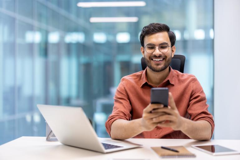 Hombre sonriendo frente a un computador
